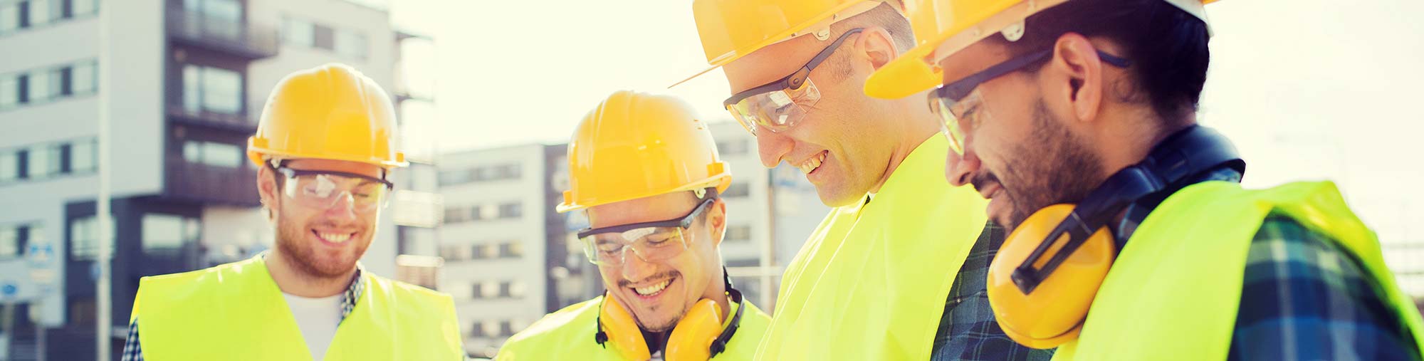 Workers in safety gear smiling